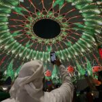 Visitors watch light projections at Al Wasl